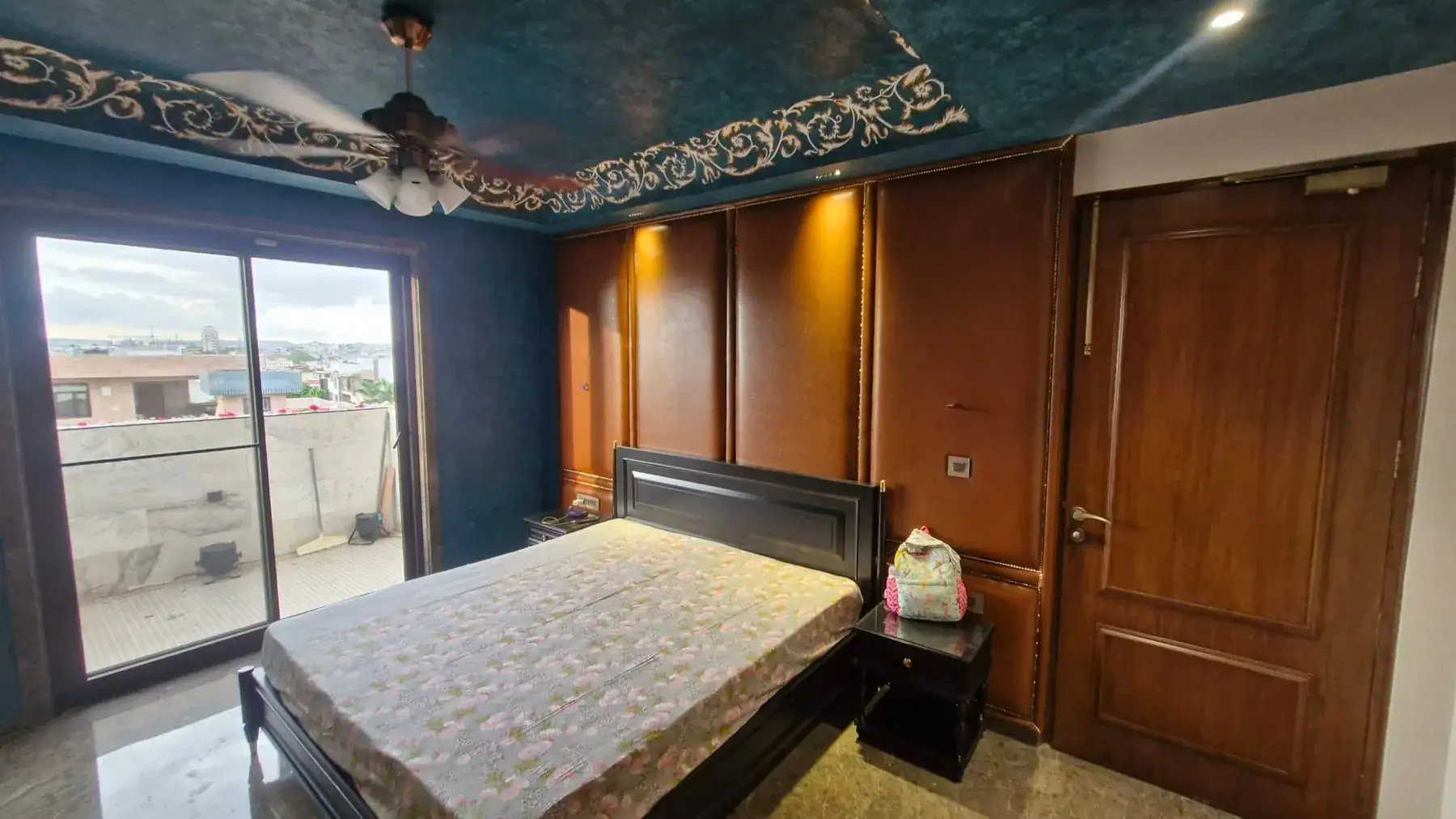 Site photo of the built bedroom with leather wall panels and an indigo ceiling with hand-painted border